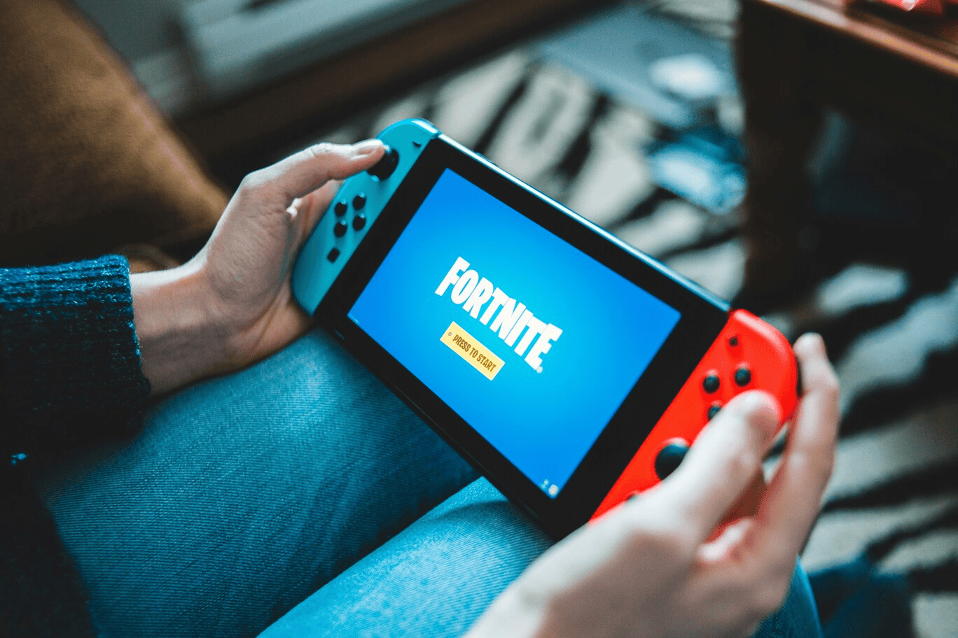 Afbeelding van persoon die Nintendo Switch vasthoudt terwijl hij/zij Fortnite speelt